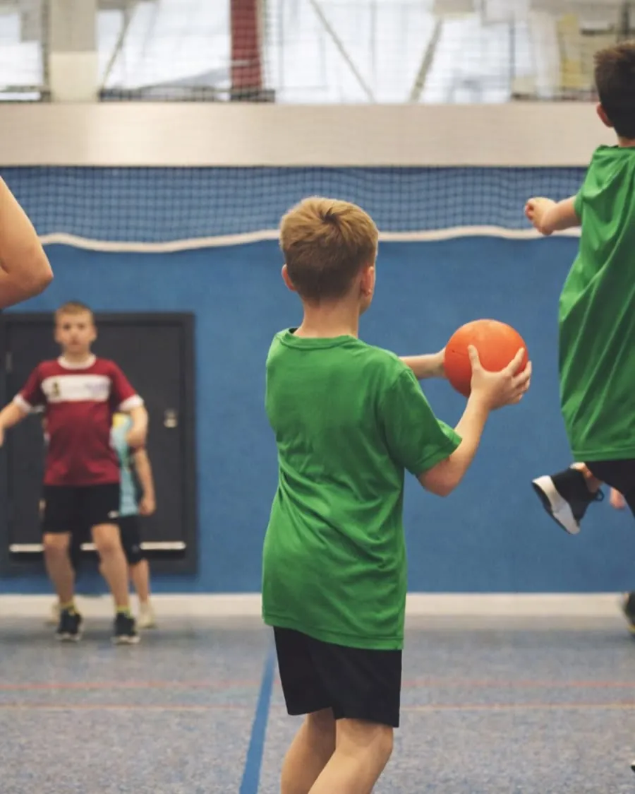Kinderen rennen met een dodgeball over het veld